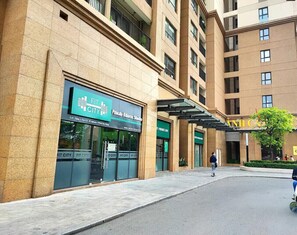 Un edificio de varios pisos con un centro de acondicionamiento físico 'Fit City' en la planta baja.