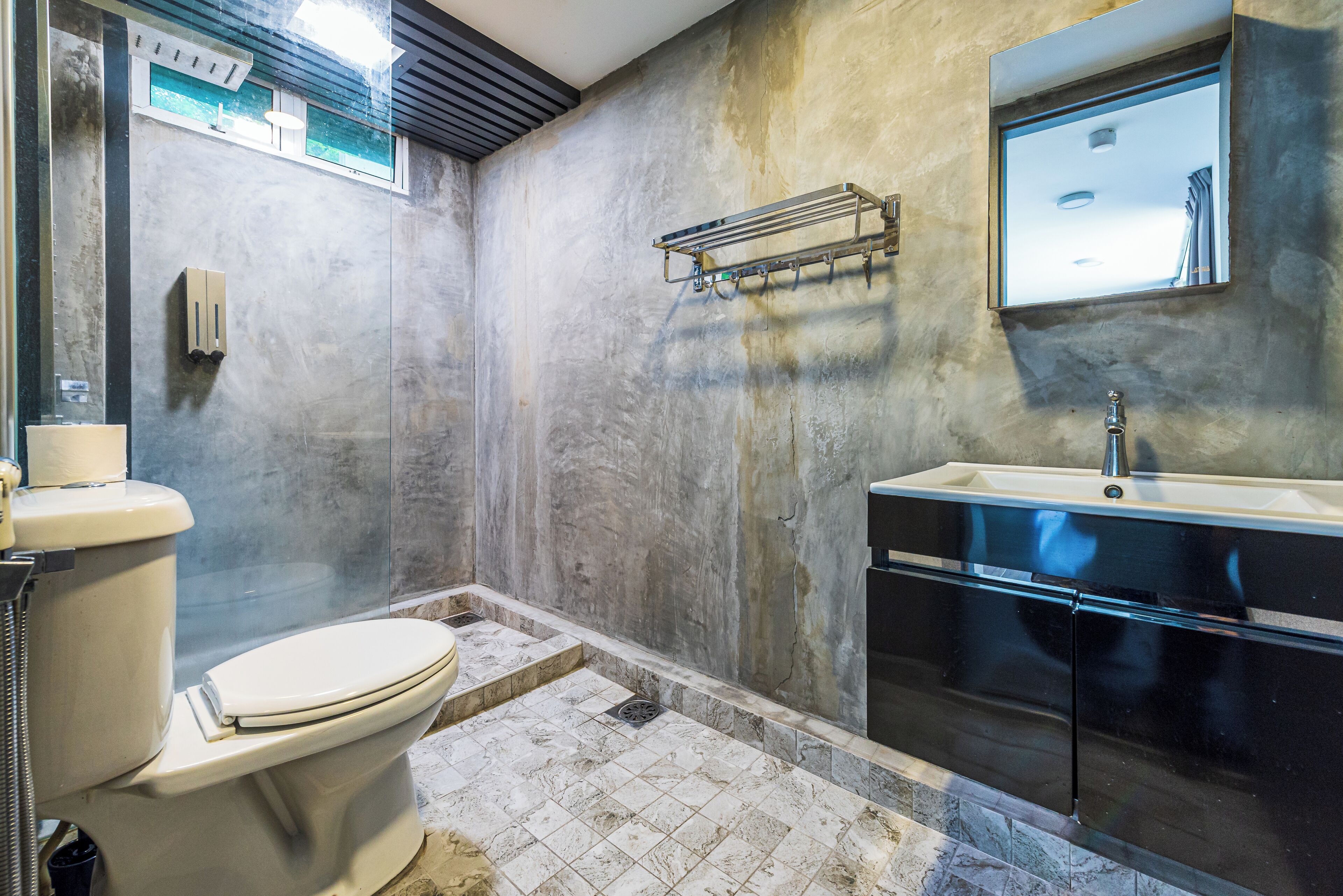 A bathroom with a toilet, sink, and a towel rack.