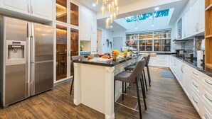 Una cocina moderna con una isla central, electrodomésticos de acero inoxidable y un tragaluz.