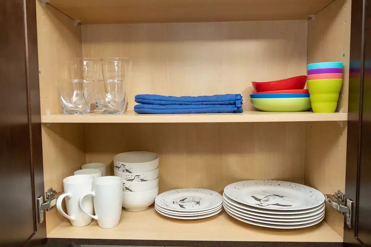 Et køkkenskab med glas, tallerkener og skåle.