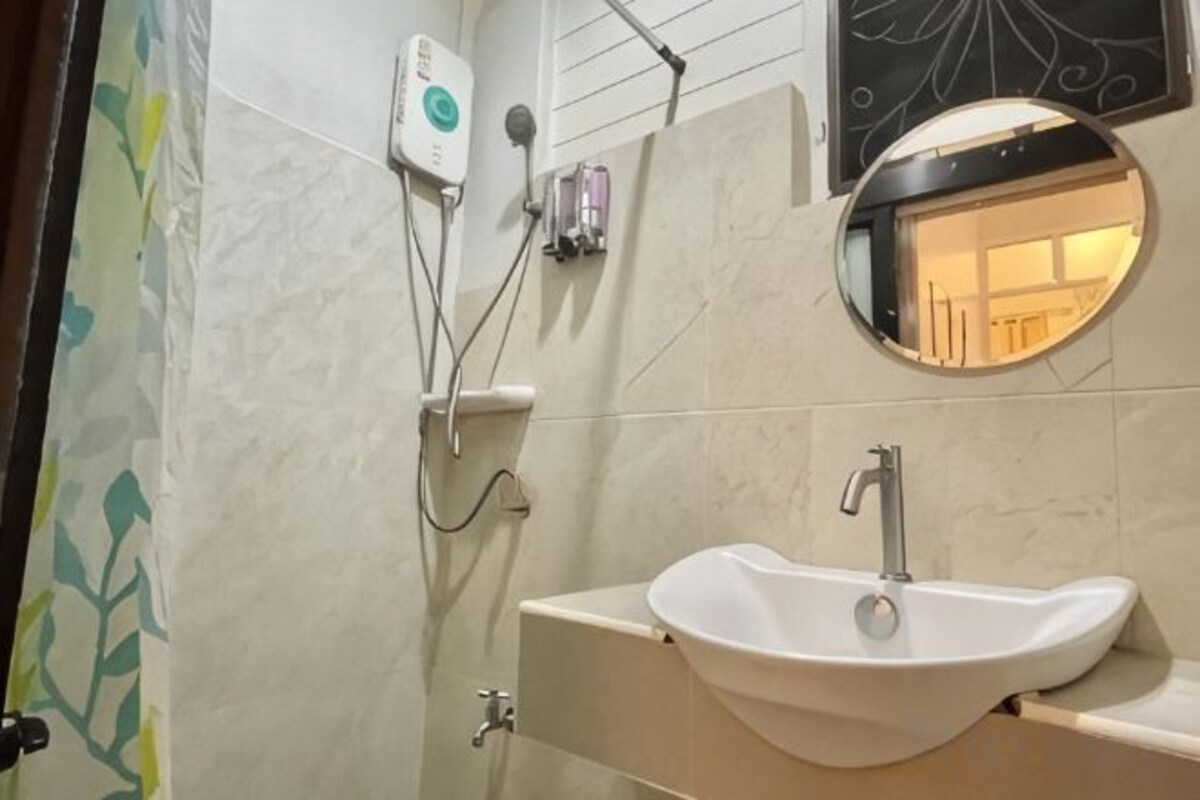 Badkamer | Een aparte badkuip en douche, een haardroger, pantoffels, een bidet
