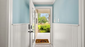 Un couloir donnant sur un jardin par une porte.