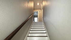 A staircase with white steps and dark wooden risers, leading to a door at the top. - Round Mountain Get Away! (Conway)