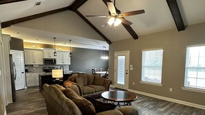 A spacious living area with a sectional sofa, a coffee table, and a ceiling fan. - Round Mountain Get Away! (Conway)