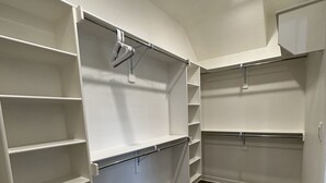 A walk-in closet with open shelving, a hanging rod, and a built-in cabinet. - Round Mountain Get Away! (Conway)