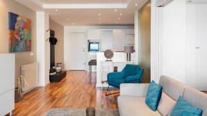 A modern living room with a sofa, a coffee table, and a blue chair. - Apartment with great sea views on the beach (Marbella)