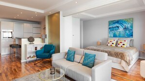 A modern hotel room with a sofa, a bed, a dining area, and a kitchen. - Apartment with great sea views on the beach (Marbella)