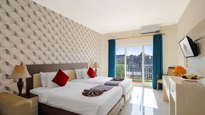 A hotel room with two beds, a TV, a desk, and a balcony with a view. - The Kanjeng Hotel Kuta (Kuta)