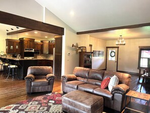 Relax in this stylish living area with a large sofa, matching ottoman, and patterned rug.