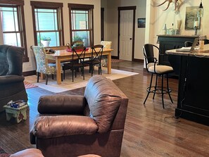 Relax in this stylish living room with a comfortable sofa, dining area, and kitchen.
