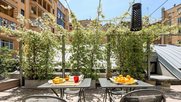 An outdoor dining area with two tables, chairs, and a variety of fruits. - WHITE HOUSES, Modern and functional studio apartment (bologna)