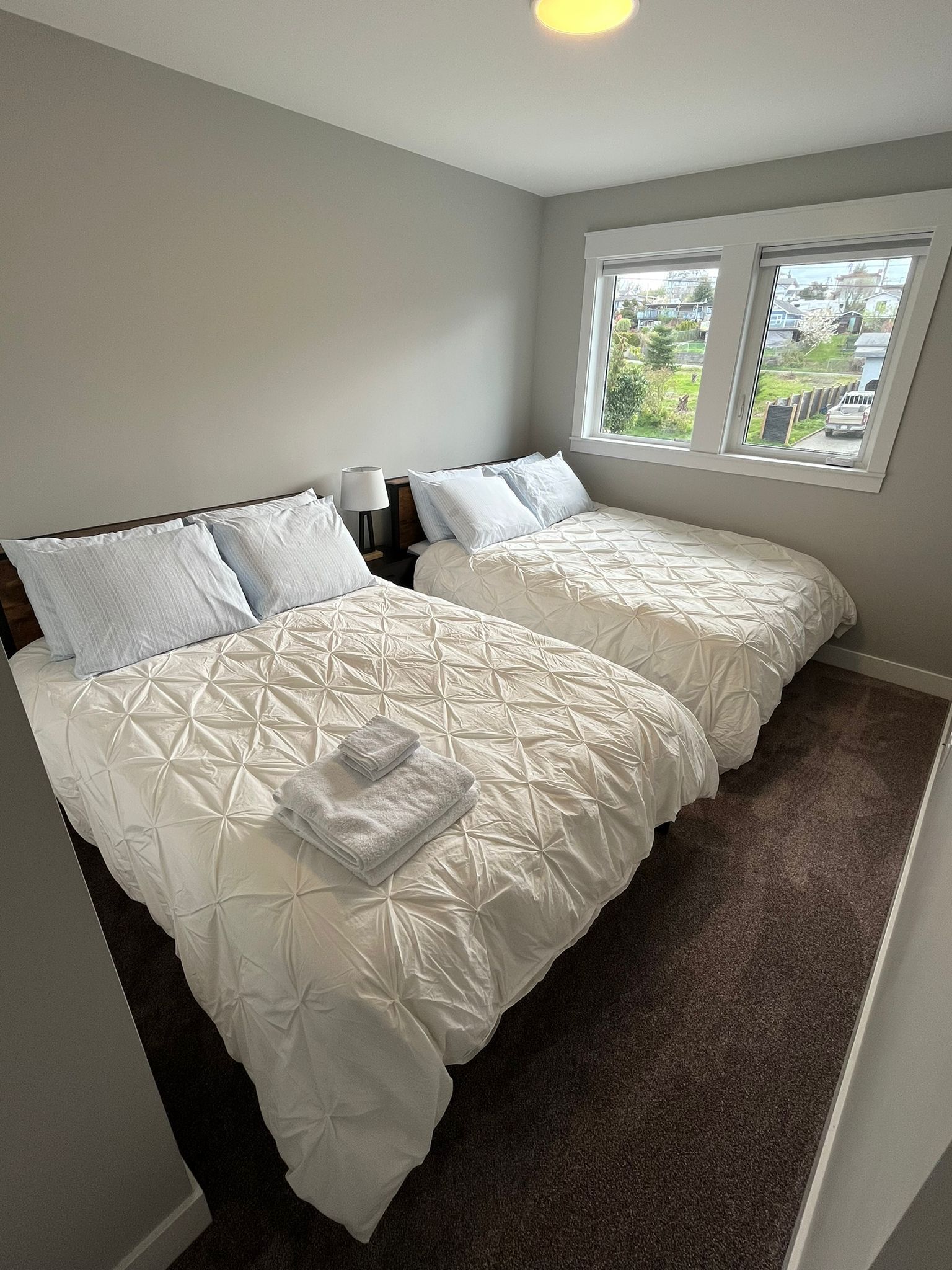Une chambre avec deux lits, une fenêtre et une vue sur l’extérieur.