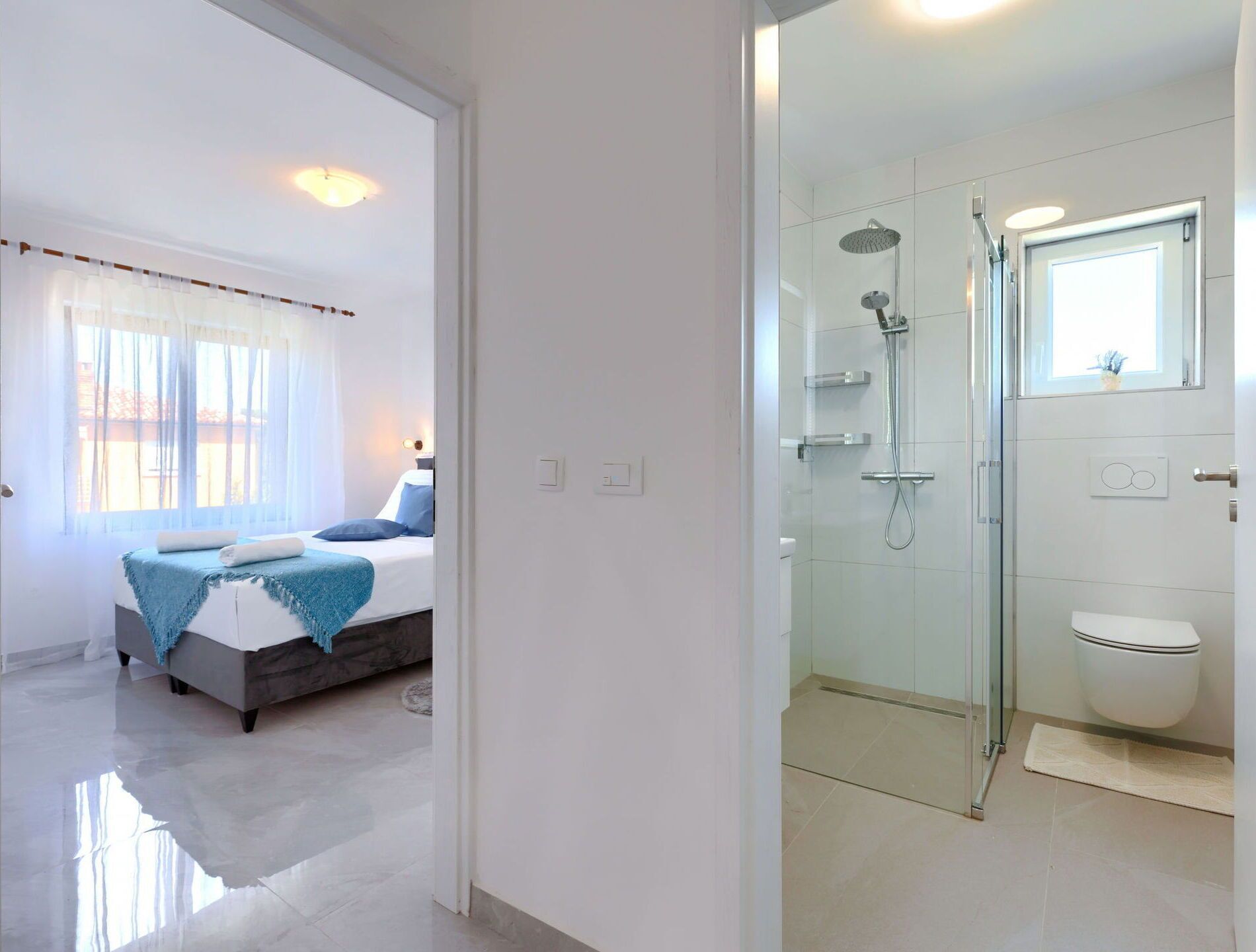Habitació d'hotel moderna amb llit, dutxa i vàter.