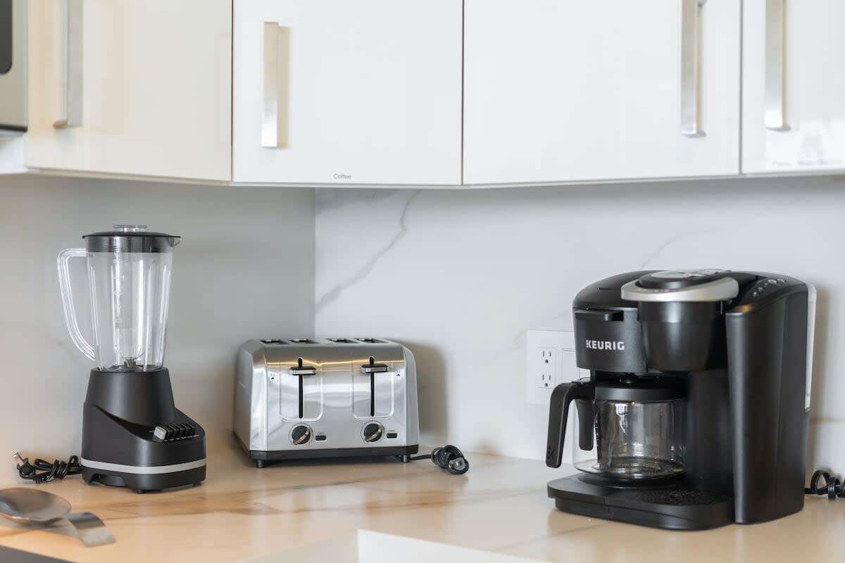 A kitchen with a blender, toaster, and coffee maker.