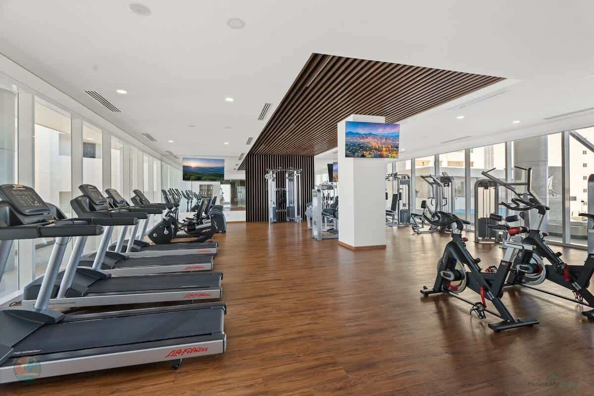 Una palestra con tapis roulant, cyclette e macchinari per l'allenamento con i pesi.