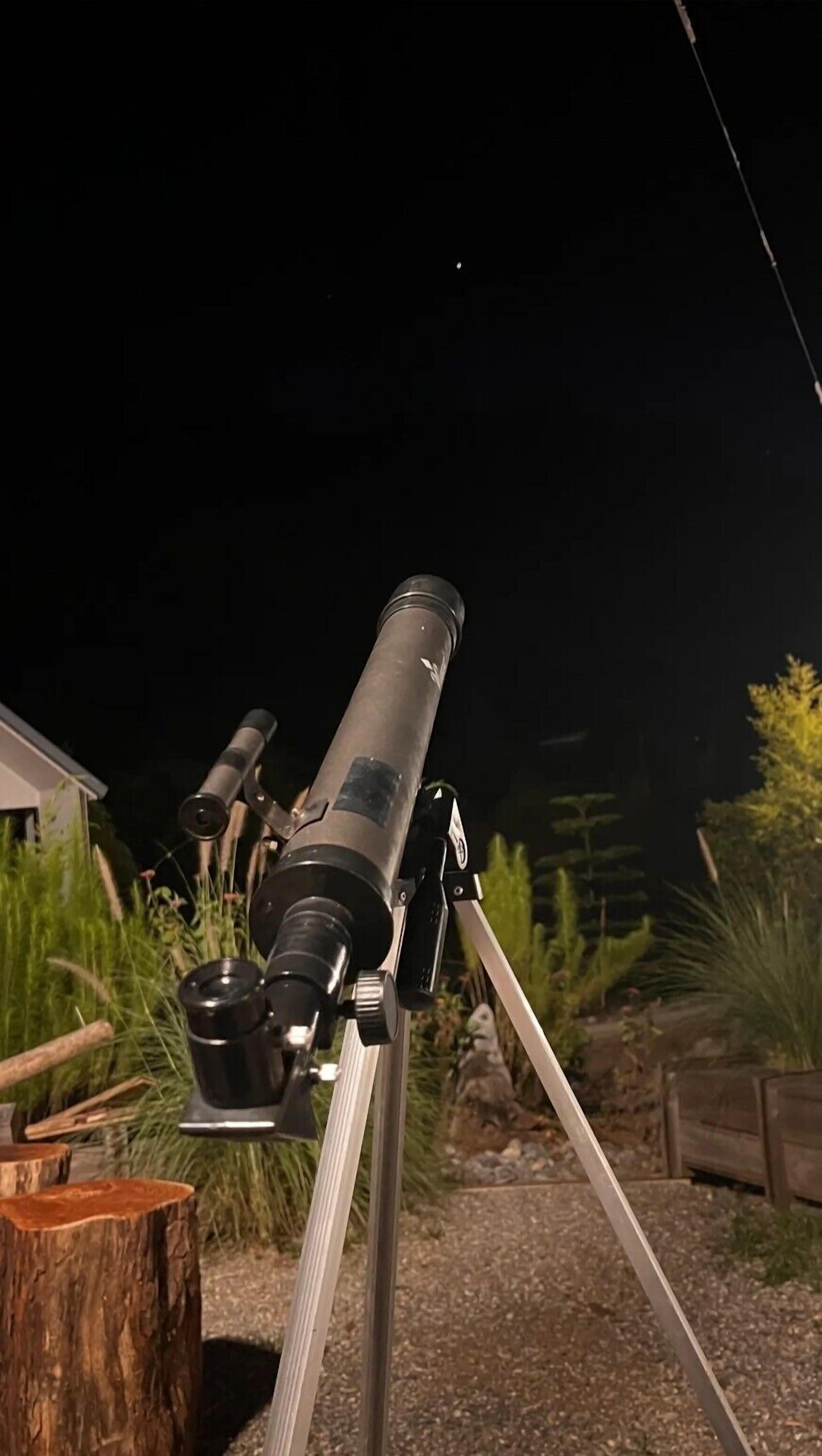 A telescope on a tripod in an outdoor setting.