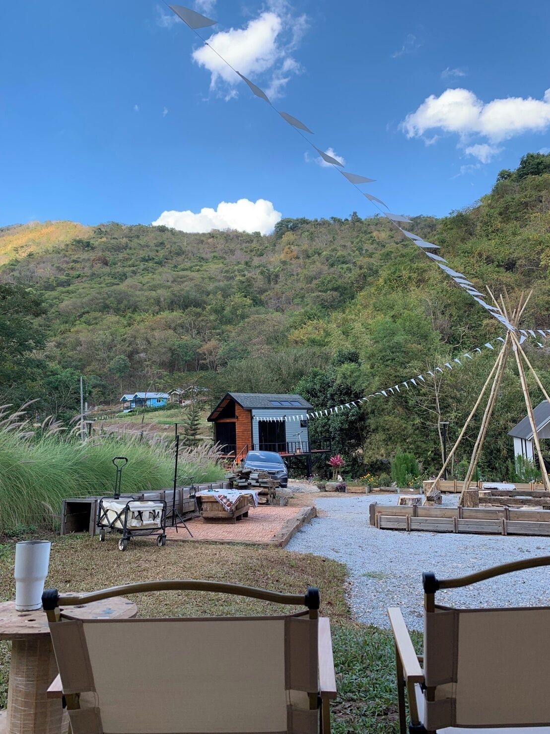 Un espacio de estar al aire libre con estilo rústico, con un camino de grava que conduce a una cabaña de madera.