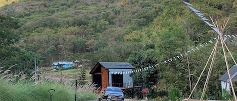Un espacio de estar al aire libre con estilo rústico, con un camino de grava que conduce a una cabaña de madera.