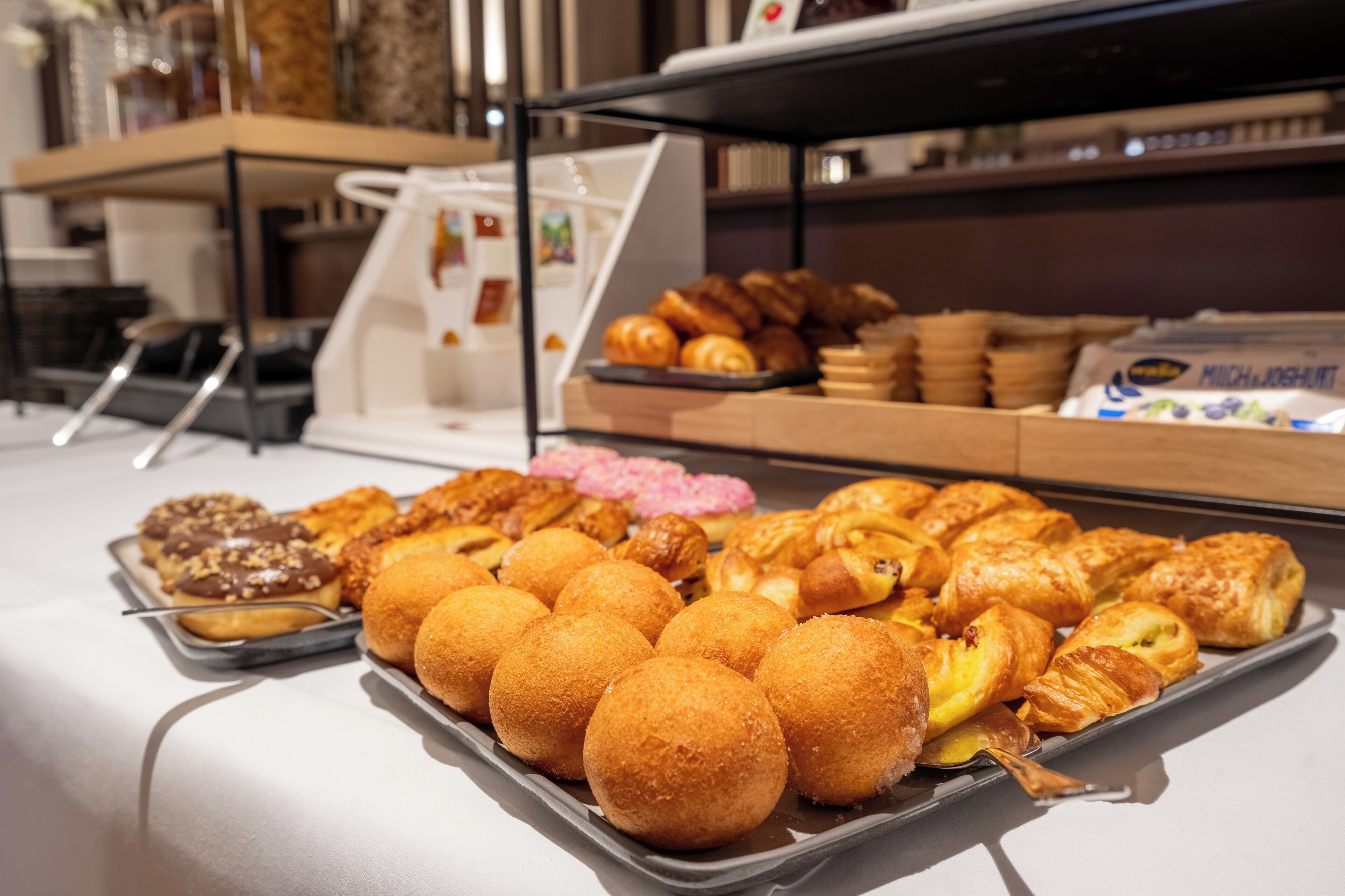 Ein Buffet mit verschiedenen Backwaren, darunter Croissants, Muffins und Gebäck.