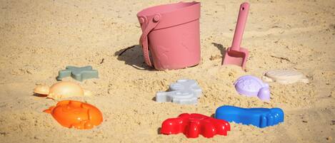 A collection of beach toys on sandy ground.