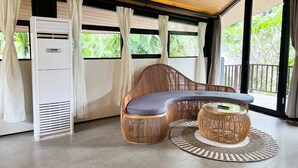 Une pièce avec un canapé incurvé, une table ronde et un ventilateur de plafond.