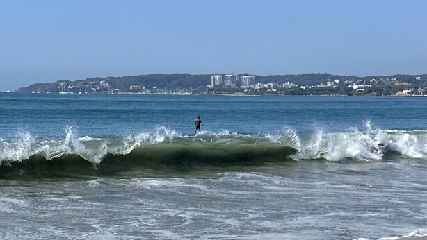 A beach with waves and a person surfing. - Home in Flamingos Residencial. (Bucerías)