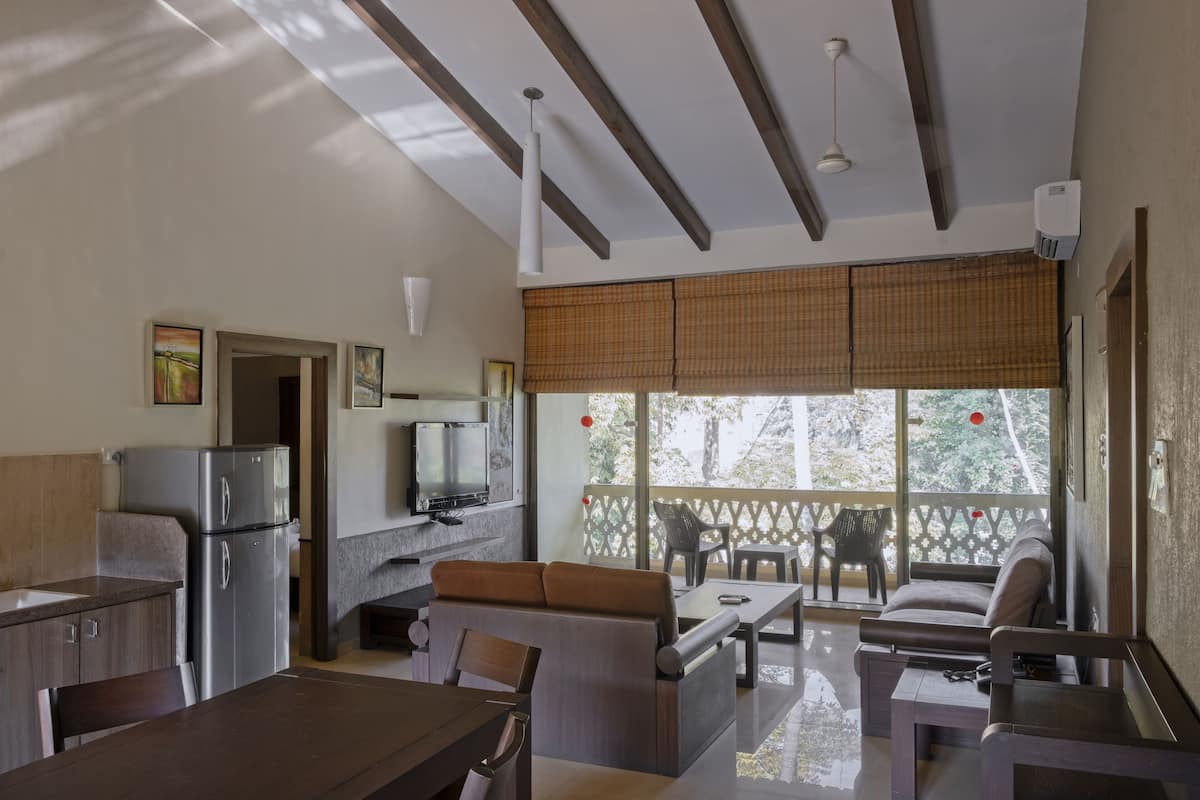 A modern kitchen with a refrigerator, stove, and dining area with a table and chairs.
