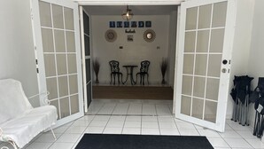Ett rum med en vit soffa, en svart matta och en matplats med två stolar och ett bord.