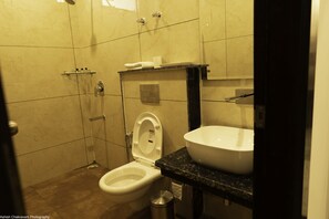 Un baño con inodoro, lavamanos y ducha.