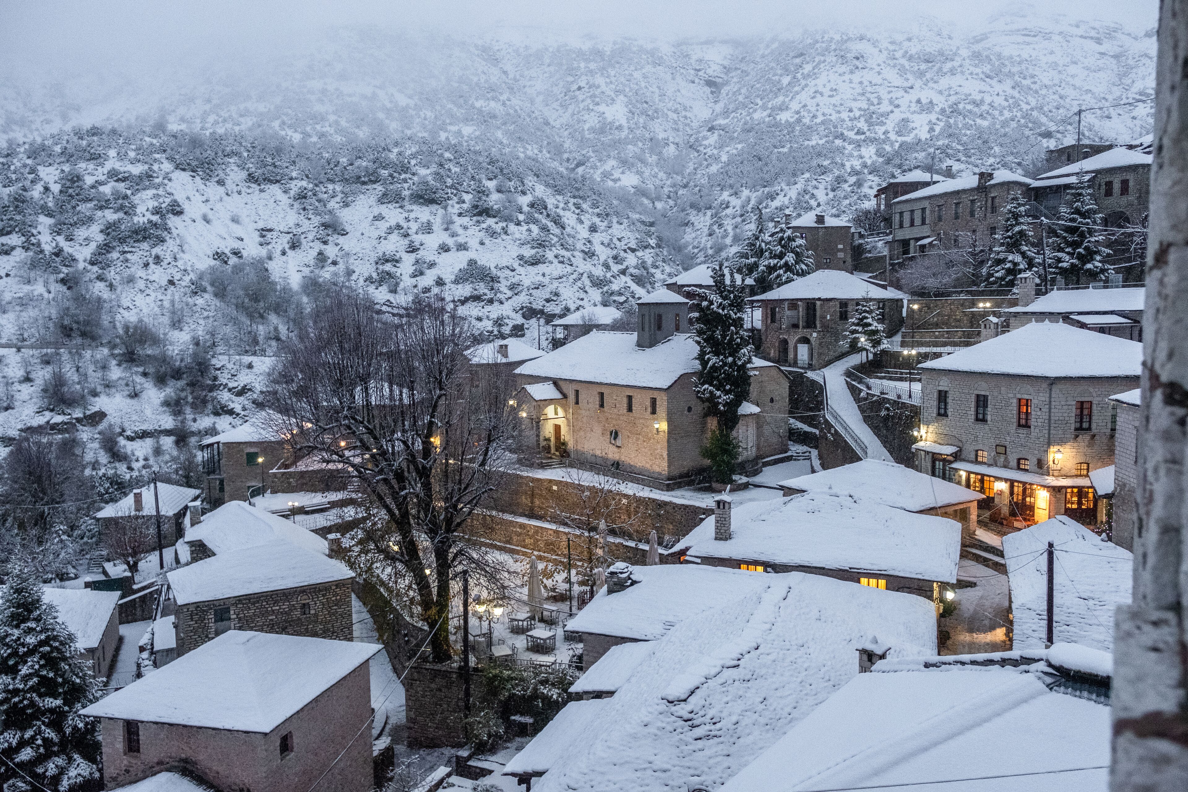 A snow-covered village with stone buildings and a church.