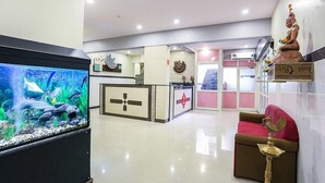 Un área de recepción con mostrador, una estatua y un acuario grande.