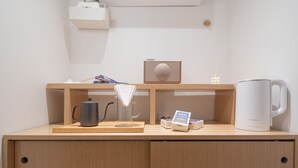 Ein Holztisch mit einem Wasserkocher, einem Radio und einer Taschentuchbox.