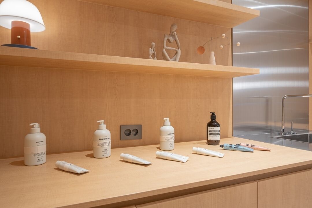 A bathroom with wooden shelves, a mirror, and various toiletries.