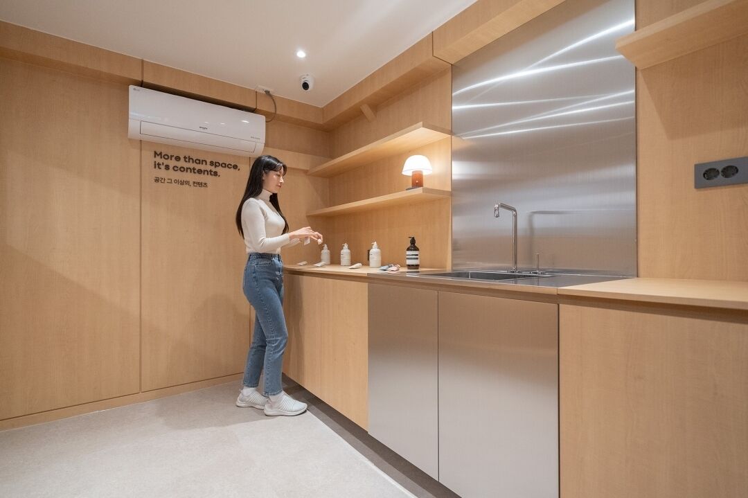 A modern kitchen with wooden cabinetry, a stainless steel refrigerator, and a built-in sink.