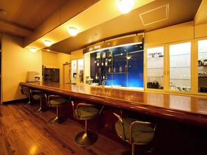 A bar area with a wooden counter, bar stools, and shelves displaying bottles. - Nonsmoking Twin with free WiFi / Minamimatsuura-gun Nagasaki (Minamimatsuura-gun)