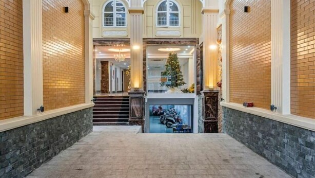 Eine geräumige Lobby mit hoher Decke, Backsteinwänden und einer zentralen Treppe zu den oberen Stockwerken.
