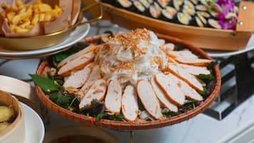 Buffet-pöydässä on tarjolla monenlaisia ruokia, kuten viipaloitua lihaa, paistettuja herkkuja ja sushia.