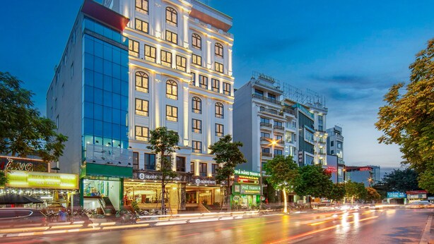 A hotel with a modern facade, multiple floors, and illuminated signage. - Gloud Hotel (Hanoi)