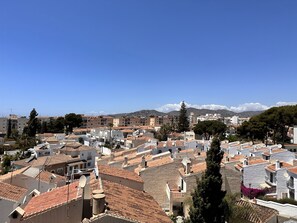 Una zona residencial con tejados de tejas de arcilla, edificios blancos y antenas parabólicas.