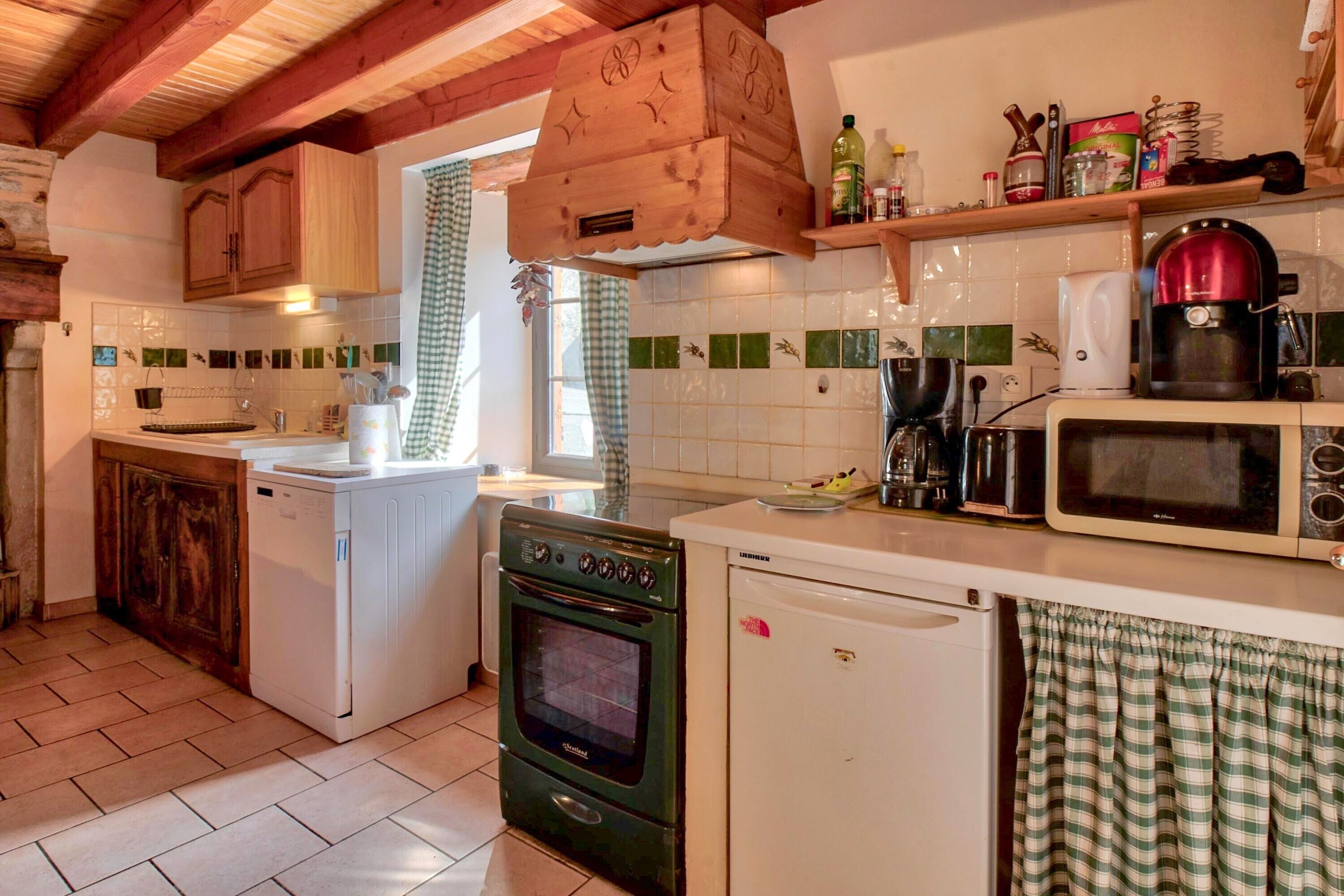 A kitchen with a stove, oven, microwave, and a wooden cabinet.