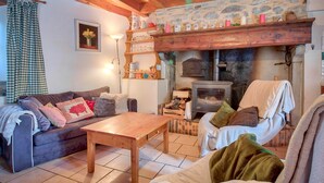Una sala de estar acogedora con chimenea, muebles de madera y una pared de piedra.