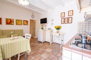 Eine Küche mit Herd, Spüle und Essbereich mit Tisch und Stühlen.