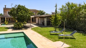 A pool area with a rectangular pool, lounge chairs, and a stone building with a tiled roof. - Country House 'Cadernera' with Private Pool, Wi-Fi and Air Conditioning (Búger)