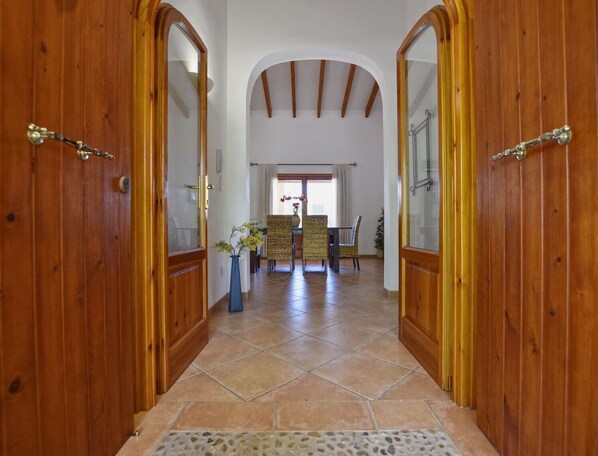 A wooden hallway with a tiled floor leading to a dining area with chairs and a table. - Holiday Home 'Correfoc' with Private Pool, Wi-Fi and Air Conditioning (Sa Pobla)