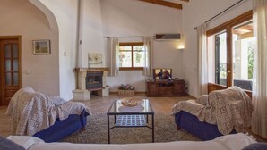 Una sala de estar con chimenea, televisor y un conjunto de sofás.