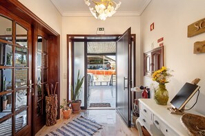 Eine Hotelhalle mit Holztür, einer Rezeption, einer Blumenvase und einem Feuerlöscher.