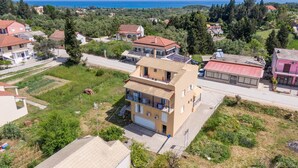 Un quartier résidentiel avec des maisons, une route et une vue sur la mer et les montagnes.