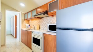 Une cuisine avec des meubles en bois, un four à micro-ondes, une cuisinière et un réfrigérateur.