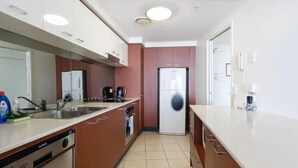 A modern kitchen with a dishwasher, sink, and coffee maker.