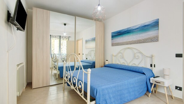 A bedroom with a bed, a TV, a painting, and a mirror. - Holiday Home 'Pullin' with Private Garden and Wi-Fi (Carasco)